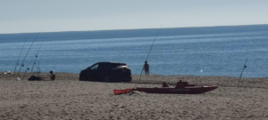con l'auto in spiaggia per pescare
