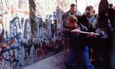 Persone picconano il Muro di Berlino