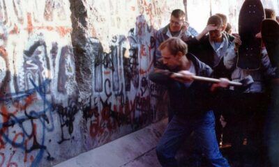 Persone picconano il Muro di Berlino