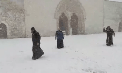 Frati che giocano con la neve nella Basilica di Assisi