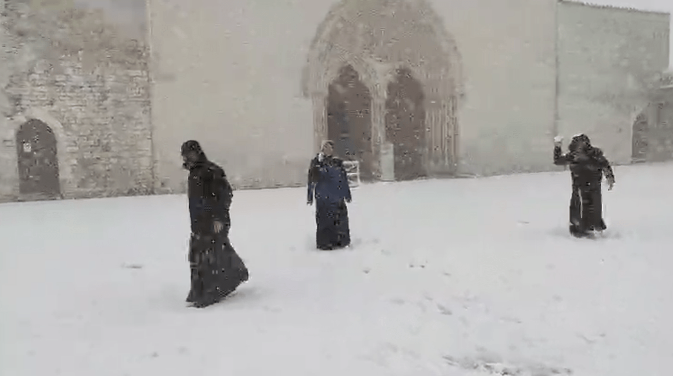 Frati che giocano con la neve nella Basilica di Assisi