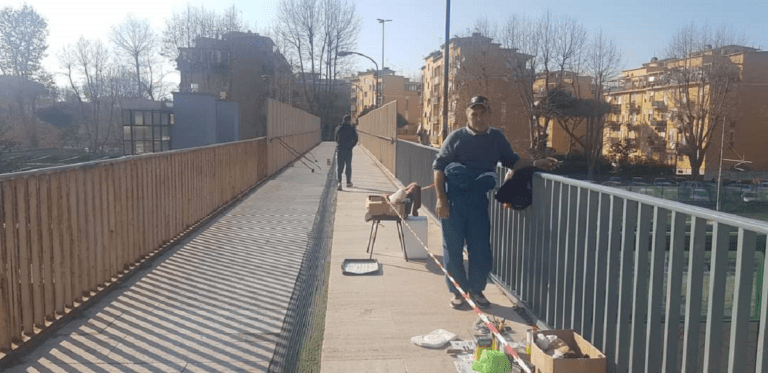 Il signor Giovanni che ha ridipinto la ringhiera del cavalcavia della Ferrovia Roma-Lido