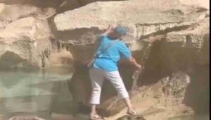 Donna riempie la bottiglietta d'acqua alla Fontana di Trevi