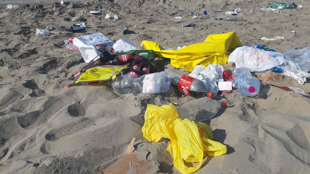 rifiuti in spiaggia dopo i falò di Ferragosto