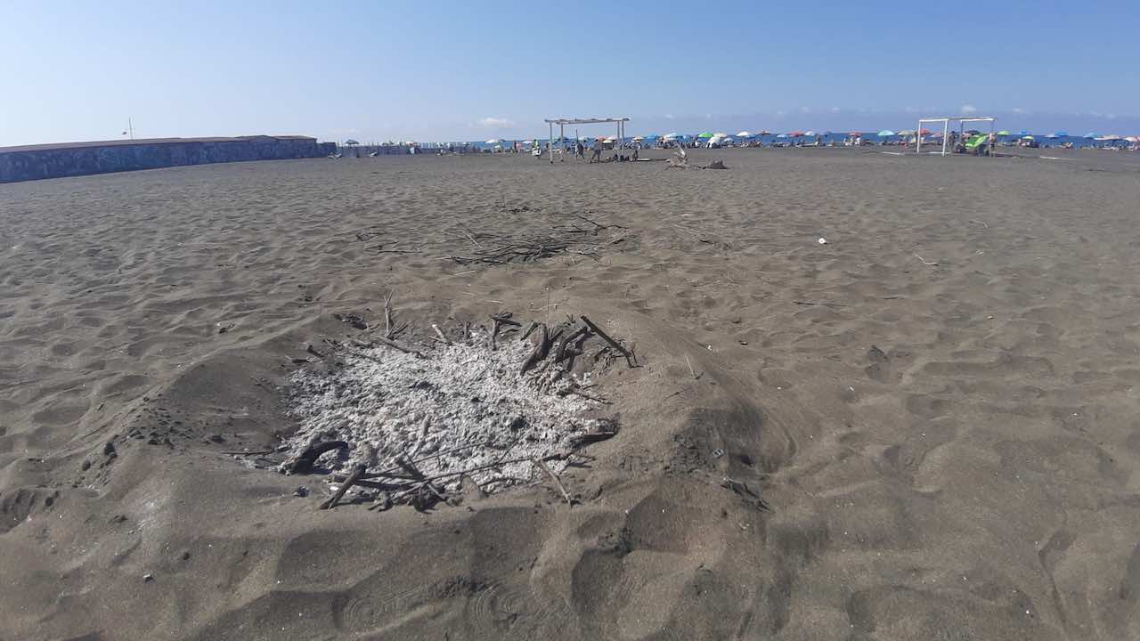 rifiuti in spiaggia dopo i falò di Ferragosto