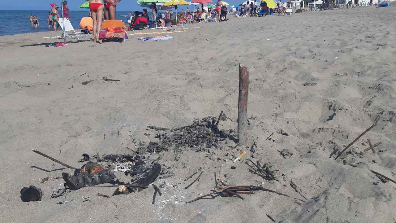 rifiuti in spiaggia dopo i falò di Ferragosto