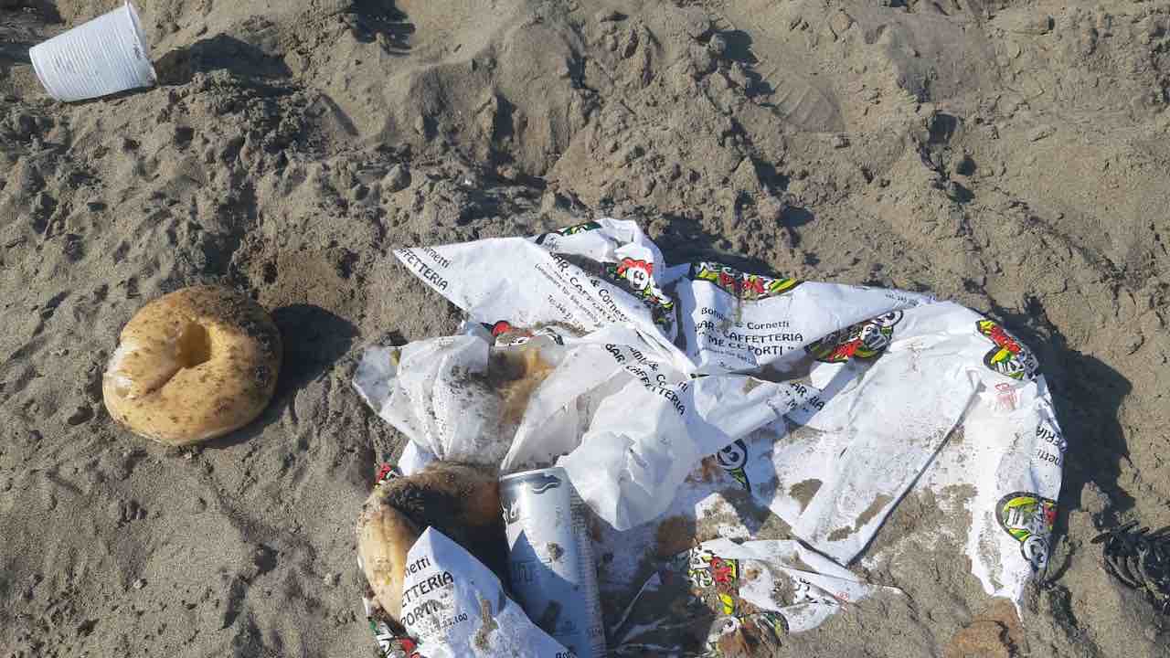 rifiuti in spiaggia dopo i falò di Ferragosto