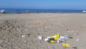 rifiuti in spiaggia dopo i falò di Ferragosto