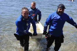 Sommozzatori tirano fuori una vasca da bagno dal Lago di Bolsena