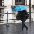 Allerta meteo lazio persone sotto la pioggia a Roma