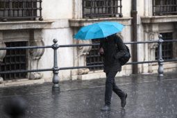 Allerta meteo lazio persone sotto la pioggia a Roma