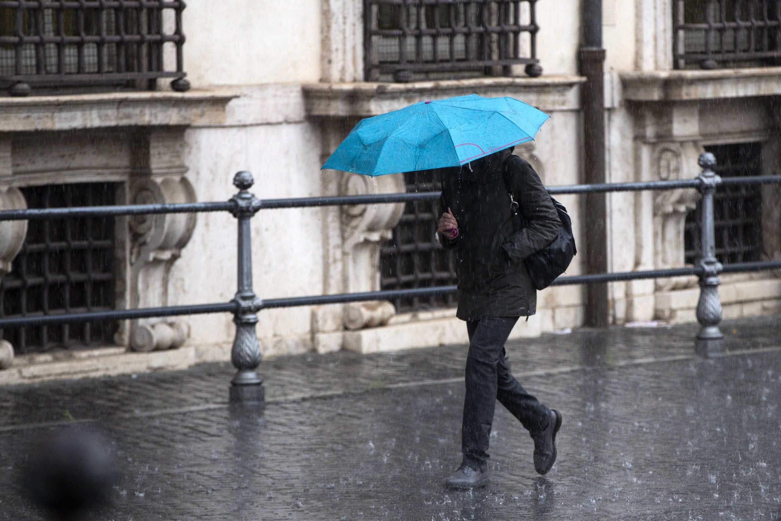 Allerta meteo lazio persone sotto la pioggia a Roma