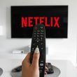 Televisore con scritta Netflix aumenti abbonamento