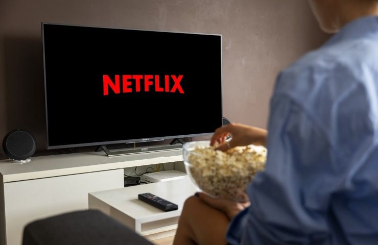 Televisore con scritta Netflix aumenti abbonamento