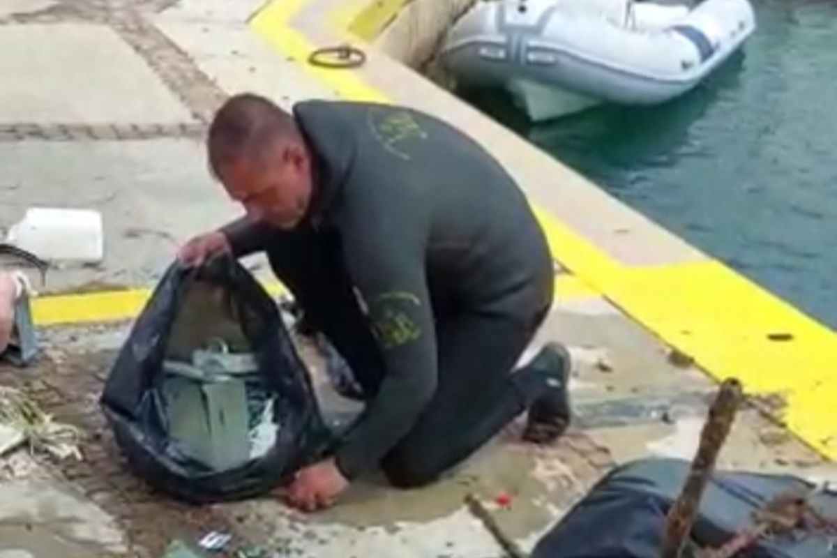 Volontario raccoglie i rifiuti sul fondale marino